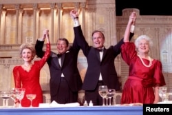 1988年5月11日,在总统晚宴上,美国总统罗纳德·里根宣布支持·布什副总统竞选总统,他们同夫人南希·里根和芭芭拉·布什携手举起臂膀。