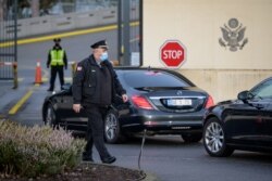 美俄为化解乌克兰危机在日内瓦举行会谈前,一名美国保安走过抵达美国驻日内瓦代表团驻地的俄罗斯官员乘坐的车队。(2022年1月10日)