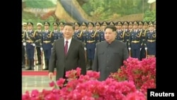 中国国家主席习近平在北京人民大会堂的欢迎仪式上同朝鲜国务委员会委员长金正恩检阅礼兵(2018年3月28日发布的视频的截图)。