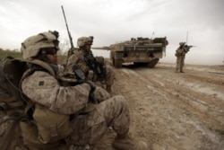 资料照片:美国海军陆战队在阿富汗马尔亚城边东北方一条交通要道巡逻时经过一辆丹麦陆军豹2A5坦克。(2010年2月21日)