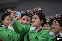 韩国首尔的学生在成人仪式中自拍。益普索公司的民调显示,韩国民众中认为会发生战争的比例只有21%。