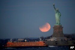 在美国纽约港口自由岛上的自由女神像和“超级月亮”(2018年1月31日)。