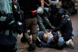 在香港抗议者举行的一次圣诞节示威活动中,防暴警察在逮捕一名抗议者。(2019年12月25日)