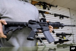 伊利诺伊州的一位枪支店主展示他出售的AR-15步枪。(资料照)