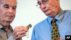 麦克丹尼尔兄弟接过父亲韩战阵亡时携带的狗牌(美联社)