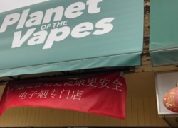 资料照片:加拿大阿尔伯塔省一家电子烟专卖店宣称电子烟比香烟更健康安全的中文横幅。(2019年8月11日)