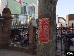 属于中国官方天主教爱国会系统的天津西开总堂在庭院内贴出的招收新教徒的学习班通知,院外是喧嚣的商业区。(2017年资料照)