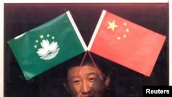 资料照:北京天安门附近一个小商贩在出售澳门和中国旗帜。