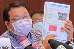 新同盟大埔区议员任启邦展示一本小学二年级常识教科书,当中提及1911年推翻满清帝制之后,没有提及成立中华民国,直接跳到1949年成立中华人民共和国,他质疑中华民国成为教师的红线。 (美国之音/汤惠芸)