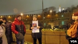 涅姆佐夫的一名支持者在他遇害的大桥上手举标语:英雄不死。(美国之音白桦拍摄)