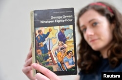 伦敦一家书店女职员手持英国作家乔治·奥威尔著作《1984》。描写集权政府对个人监控无所不在的名著《1984》于1949年6月8日出版,在2013年重回畅销书排行榜。(2013年6月9日)