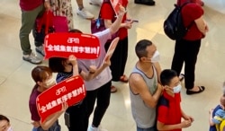 在观塘一个商场观看奥运电视直播的市民手持标语,支持香港单车选手李慧诗。 (美国之音/汤惠芸)