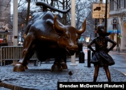 纽约华尔街附近著名的铜牛像对面,树立起“无畏女孩”铜像,迎接国际妇女节(2017年3月7日)