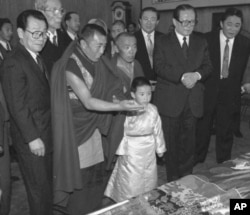 1996年1月12日,中国官方选择的六岁的11世班禅喇嘛向中国主席江泽民呈现给他的礼品。中国政协主席李瑞环在场。