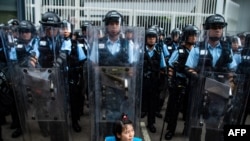 2019年6月12日,香港立法会外,一名抗议者坐在防暴警察面前。