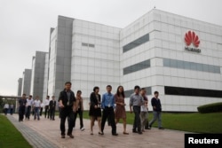 华为技术有限公司的员工走过广东省深圳市的公司办公楼(2012年4月17日)。