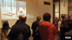 参观者观看关于一处集体墓葬地的图片。(美国之音白桦拍摄)