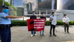 多名民主派区议员8月7日下午到政府总部”公民广场”外召开记者会,抗议特首林郑月娥聘用3间中资化验所进行全民病毒检测,有警员上前警告他们涉嫌违反公众地方不可以超过2人聚集的防疫”限聚令”。 (美国之音汤惠芸拍摄)