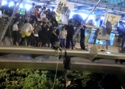 香港理工大学学生在一道人行桥上使用绳索试图逃离大学校园。(2019年11月18日)