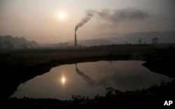 印度一家砖窑厂的大烟囱冒着烟(资料照片)