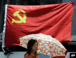 在上海,一名妇女在中共党旗下走过