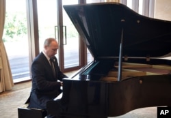 在北京的 “一带一路”国际合作高峰论坛开幕式之前,在中国主席习近平和俄罗斯总统普京会谈之前,普京弹钢琴(2017年5月14日)