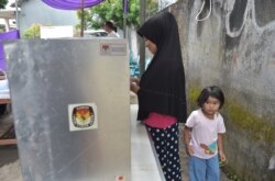 Seorang pemilih sedang melaksanakan hak pilih saat pilkada Tangerang, Banten 27 Juni 2018. (Foto: AFP)