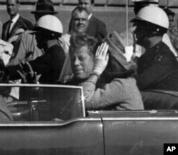 肯尼迪总统及其夫人杰奎林1963年11月22日坐在一辆敞篷车上在达拉斯行驶,几分钟后肯尼迪总统遇刺