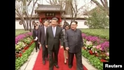 中国国家主席习近平在北京钓鱼台国宾馆的养源斋前面同朝鲜国务委员会委员长金正恩边走边谈(2018年3月28日发布的视频的截图)