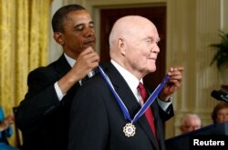 奥巴马总统在白宫把总统自由勋章授予前宇航员和参议员约翰·格伦。(2012年5月29日)
