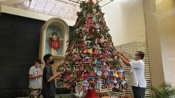 Romo Marcelinus Hardo Iswanto, CM, Pastor Kepala Paroki Kristus Raja Surabaya, turut menaruh masker pada pohon natal protokol kesehatan (foto Petrus Riski-VOA).