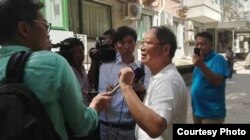 炎黄春秋杂志社负责人胡德华在被强占的办公地点外面接受外媒采访(网络图片)