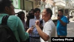 炎黄春秋杂志社负责人胡德华在被强占的办公地点外面接受外媒采访。(网友提供)