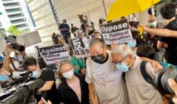 香港天主教教区荣休主教陈日君枢机(右一)到西九龙裁判法院声援8-18案被告,与其中两名被告李卓人及何秀兰打招呼 (美国之音/汤惠芸)