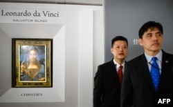 2017年10月13日,被香港媒体认定为前美国中央情报局特工李振成(音译)的男子(打蓝色领带者)站在佳士得香港展厅的保安员前面,身后是达芬奇的画作 。