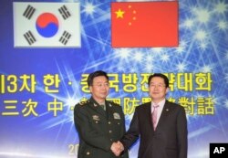 韩国国防部次官白承周(右)与中国人民解放军副总参谋长王冠中在首尔参加第三次韩中国防战略对话。(2013年11月28日)