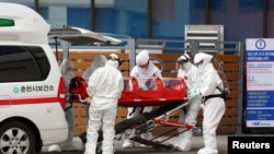 一位确诊感染冠状病毒的病人在韩国春川被推进一家医院(2020年2月20日)。