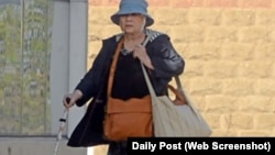 Bà Nguyen Thi Lien, 73 tuổi, chống gậy tới tòa.