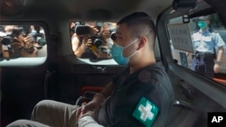 香港首位被控涉嫌违反国安法的男子唐英杰（Tong Ying-kit）坐着轮椅由警车押解至法院应讯。（2020年7月6日）