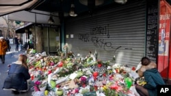 哀悼者把鲜花和蜡烛放在出事的巴黎餐厅前面(2015年11月15日)