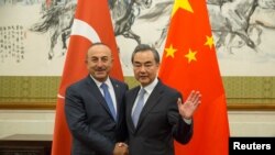 Ngoại trưởng Trung Quốc Vương Nghị (phải) bắt tay Ngoại trưởng Thổ Nhĩ Kỳ Mevlut Cavusoglu trong một cuộc gặp gỡ tại Nhà khách ở Bắc Kinh, Trung Quốc, ngày 3 tháng 8, 2017.