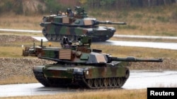 资料照:美国士兵驾驶M1A2艾布拉姆斯主战坦克在德克萨斯州一处军事基地与北约盟国一起参加多国联合军演。