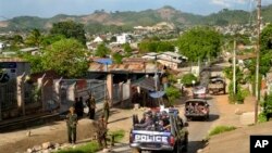 ရှမ်းပြည်နယ်၊ လားရှိုးမြို့တွင်း ရဲလုံခြုံရေးကင်းလှည်ယာဉ်နားမှာ ရပ်နေသော စစ်တပ်အရာရှိတစ်ဦးကို မြင်ရစဉ်။ (မေ ၂၉၊ ၂၀၁၃။)