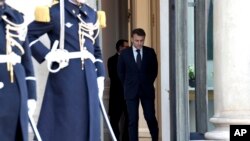 2025年2月17日,法国总统埃马纽埃尔·马克龙(右)在巴黎爱丽舍宫等候参加有关乌克兰会议的欧盟主要国家和英国领导人。