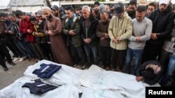 Para pelayat berdoa di samping jenazah selama pemakaman jurnalis Palestina dari saluran televisi Al-Quds Al-Youm yang tewas dalam serangan udara Israel di Deir Al-Balah, Jalur Gaza tengah, 26 Desember 2024.