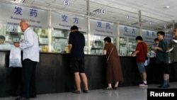 资料照:北京一家医院的病人在医院药房取药。