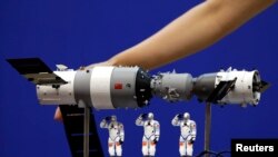 资料照: 在酒泉卫星发射中心展示的中国神舟9号飞船与三名中国宇航员的模型。(2012年6月15日)