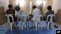 Phụ nữ Philippines tham khảo ý kiến của chồng khi họ bỏ phiếu tại một địa điểm bầu cử ở Manila, ngày 13/5/2013.