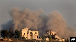 2024年9月24日,从黎巴嫩南部的马尔加尤恩镇看到,以色列空袭基亚姆村后,一座被毁房屋后面升起浓烟。(美联社照片)