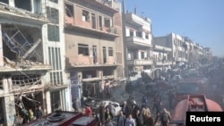 叙利亚官方通讯社提供的图片显示叙利亚军民在霍姆斯市检查爆炸地点(2015年12月28日)